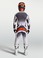 Alpinestars Techstar Swan, calças de motocross para homem, lilás e cinzento com vermelho fluo, vista traseira.