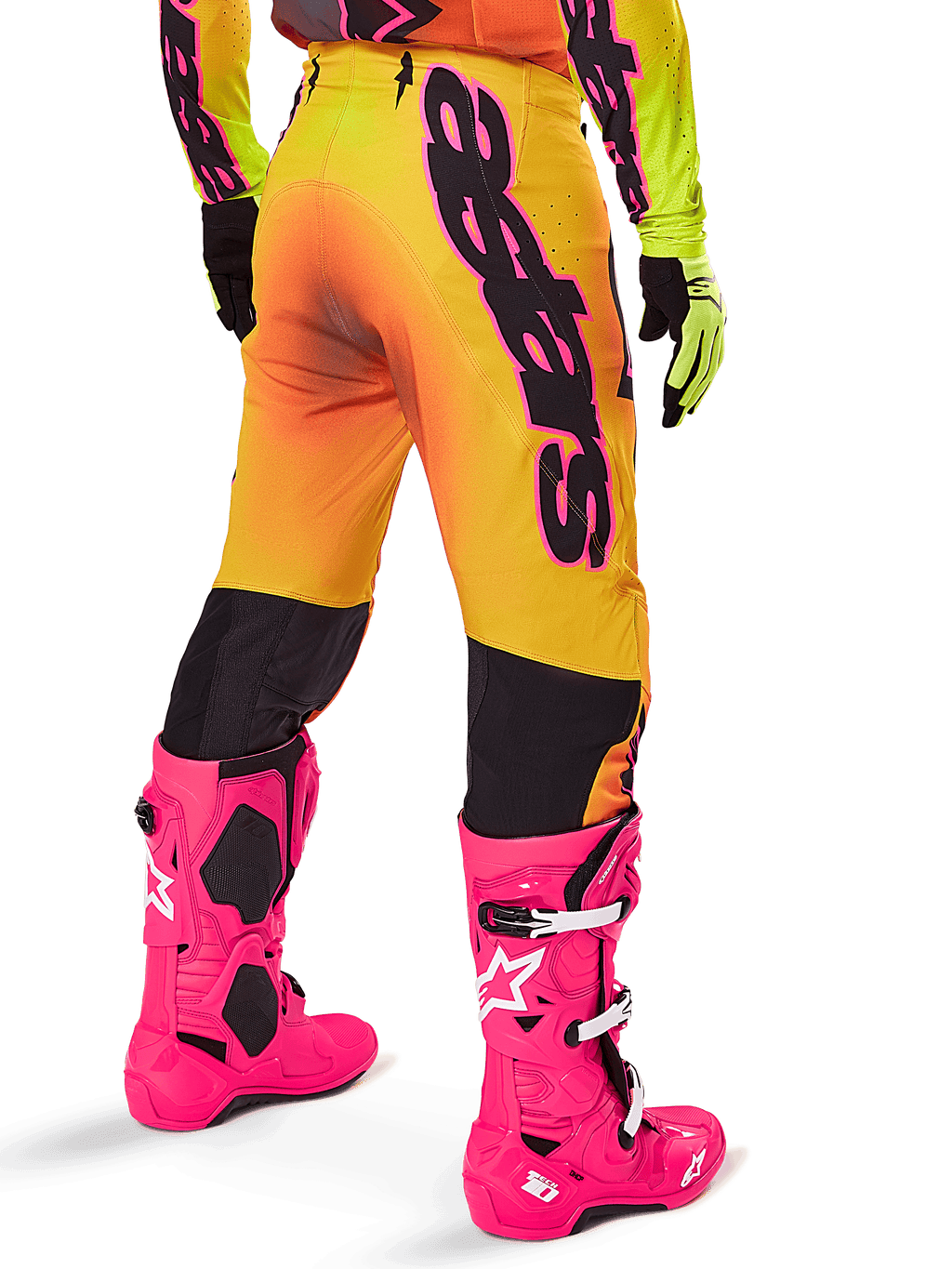 Alpinestars 2025 Supertech Lipan Gear Set, vista traseira de calças de motocross com gradiente amarelo e laranja e marca preta em destaque, combinadas com botas Tech 10 cor-de-rosa vivo e luvas amarelas, equipamento profissional de corrida todo-o-terreno