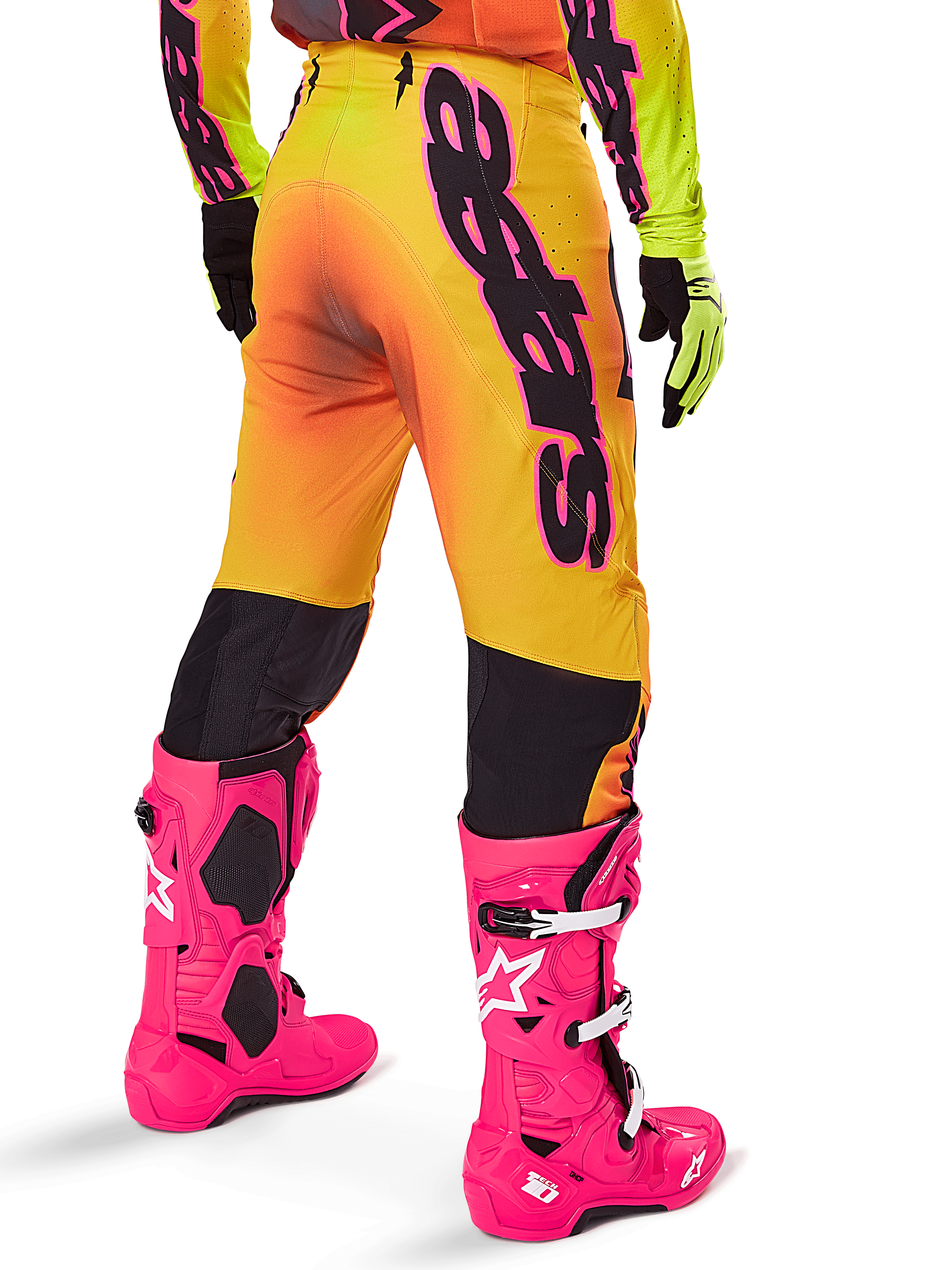 Alpinestars 2025 Supertech Lipan Gear Set, vista traseira de calças de motocross com gradiente amarelo e laranja e marca preta em destaque, combinadas com botas Tech 10 cor-de-rosa vivo e luvas amarelas, equipamento profissional de corrida todo-o-terreno