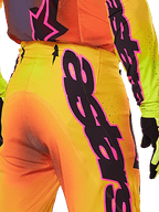 Alpinestars 2025 Supertech Lipan Pants, vista detalhada traseira e lateral, design com gradiente amarelo e laranja, logótipo Alpinestars proeminente em rosa e preto, equipamento profissional de motocross