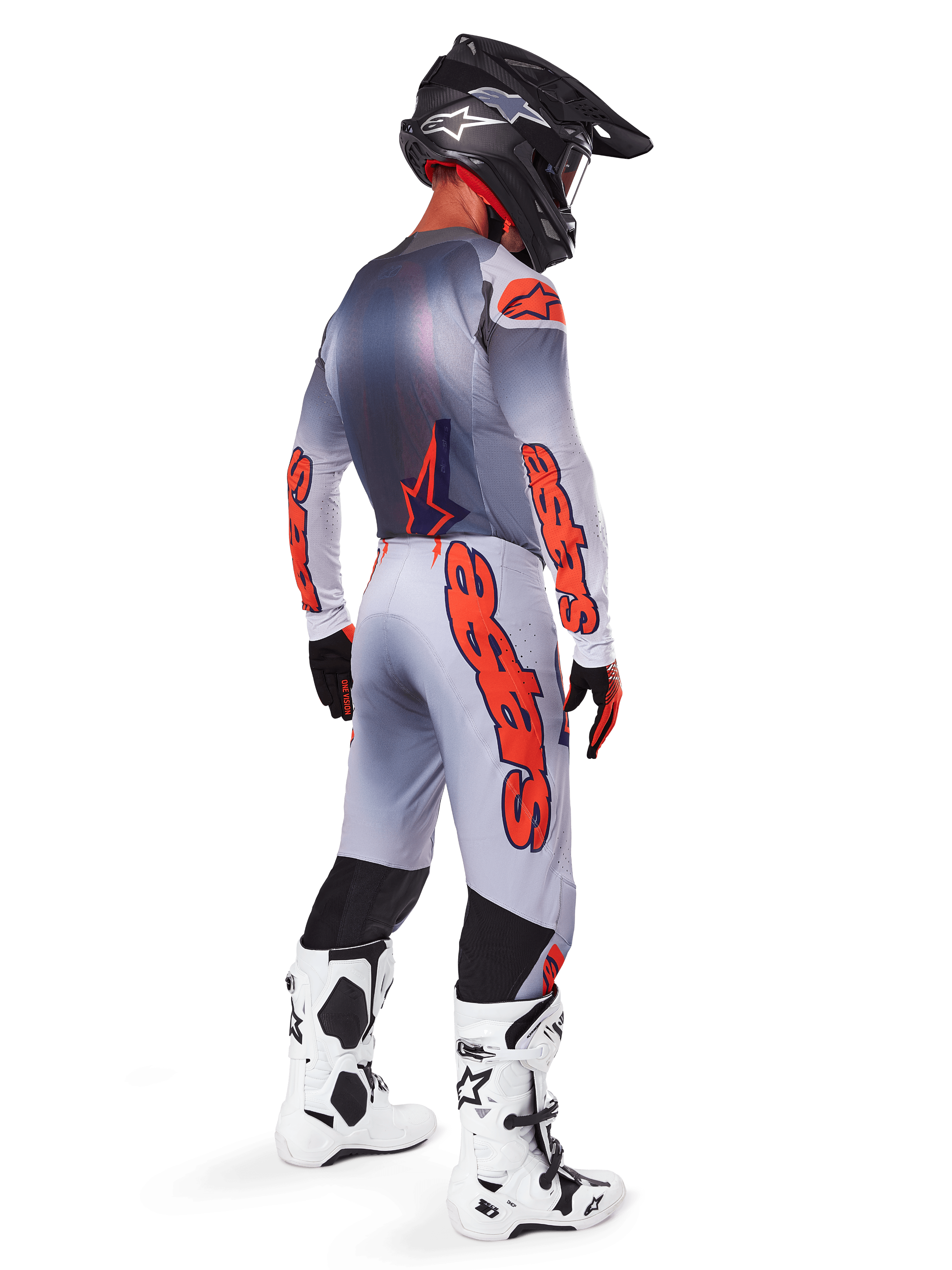 Motocross rider from the back wearing Alpinestars 2025 Supertech Lipan Pants in Gray and Orange Fluo, matching long-sleeve jersey, black helmet, and white and black tech boots, complete professional off-road racing gear.