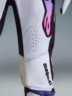 Calças Alpinestars 2026 Supertech AFD Vista, calças de motocross, brancas, roxas e pretas, grande plano que mostra os orifícios de ventilação cortados a laser, logótipo vertical da Alpinestars e painéis interiores dos joelhos em bege, equipamento de corrida de alta performance