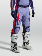 Alpinestars Racer Air Hunt, calças de motocross ventiladas roxas e rosa, modelo com botas brancas para off-road.