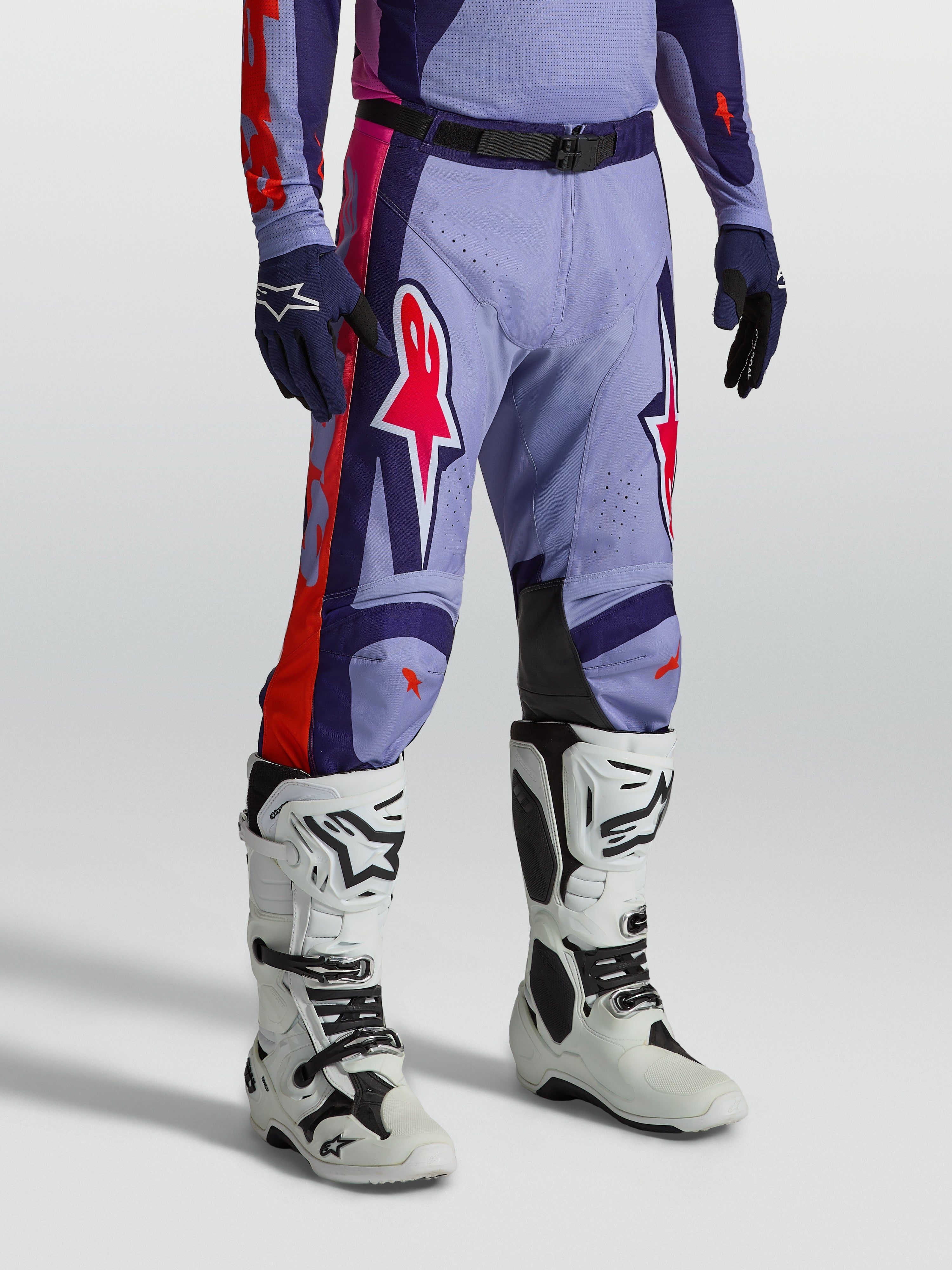Alpinestars Racer Air Hunt, calças de motocross ventiladas roxas e rosa, modelo com botas brancas para off-road.