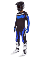 Conjunto de Equipamento Alpinestars Techstar Dreem 2025, equipamento de motocross em preto e azul, incluindo camisola e calças com logótipos brancos, usado com capacete preto, luvas azuis e pretas, e botas brancas e pretas, conjunto de corrida completo para performance em todo-o-terreno