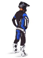 Calças Alpinestars Techstar Dreem 2025, calças de motocross, preto e azul, usadas por um piloto num conjunto completo de equipamento com camisola a condizer, capacete preto e botas brancas, com logótipo branco em destaque na parte traseira e um corte de corrida focado no desempenho.