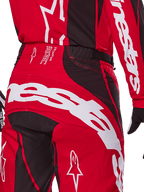 Calças Alpinestars Techstar Dreem 2025, calças de motocross, vermelho vivo e preto, grande plano da zona traseira da cintura e do assento com branding Alpinestars em destaque a branco, painéis elásticos pretos e texto técnico no cós, concebidas para performance em corridas todo-o-terreno.