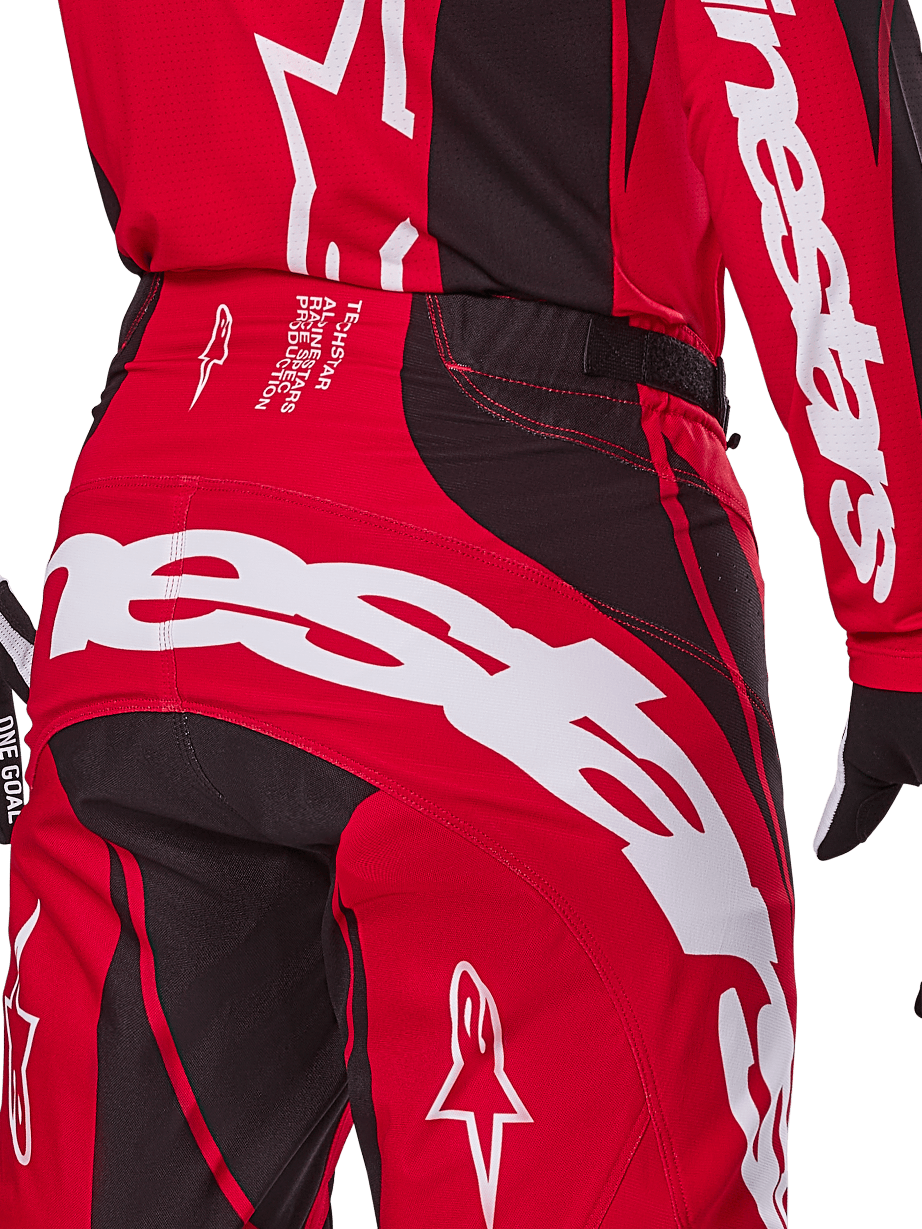 Calças Alpinestars Techstar Dreem 2025, calças de motocross, vermelho vivo e preto, grande plano da zona traseira da cintura e do assento com branding Alpinestars em destaque a branco, painéis elásticos pretos e texto técnico no cós, concebidas para performance em corridas todo-o-terreno.