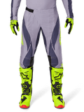 Alpinestars 2025 Techstar Dreem Pants, calças de motocross, cinzento claro e cinzento escuro com pormenores em amarelo néon, combinadas com botas e luvas em amarelo néon, ventilação cortada a laser, fivelas pretas e solas vermelhas, equipamento de motocross profissional