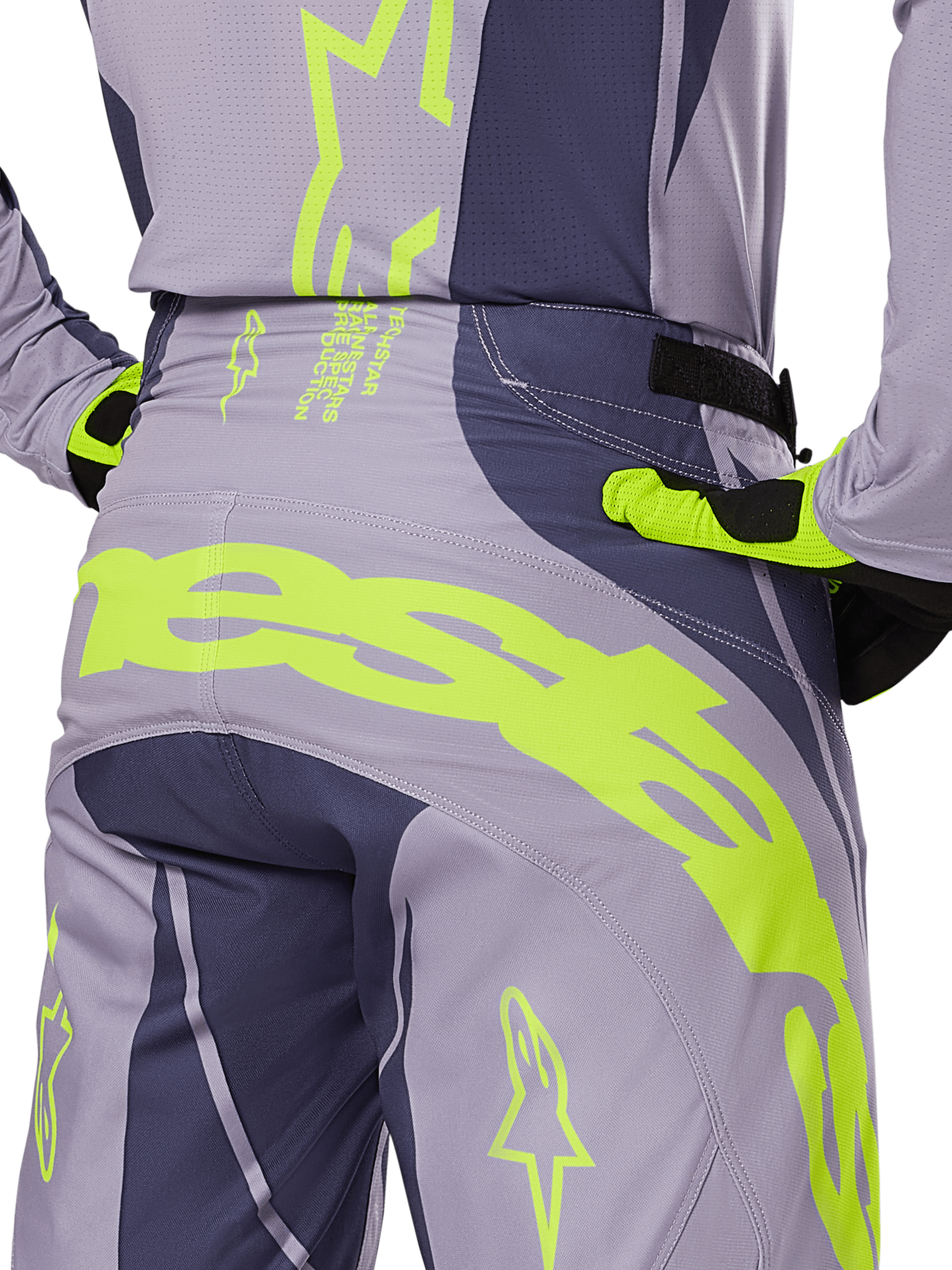 Alpinestars 2025 Techstar Dreem Pants, calças de motocross, cinzento e cinzento escuro com detalhes em amarelo néon, vista traseira com logótipo Alpinestars em destaque na zona da pala, usadas com camisola e luvas a combinar, concebidas para corridas todo-o-terreno.