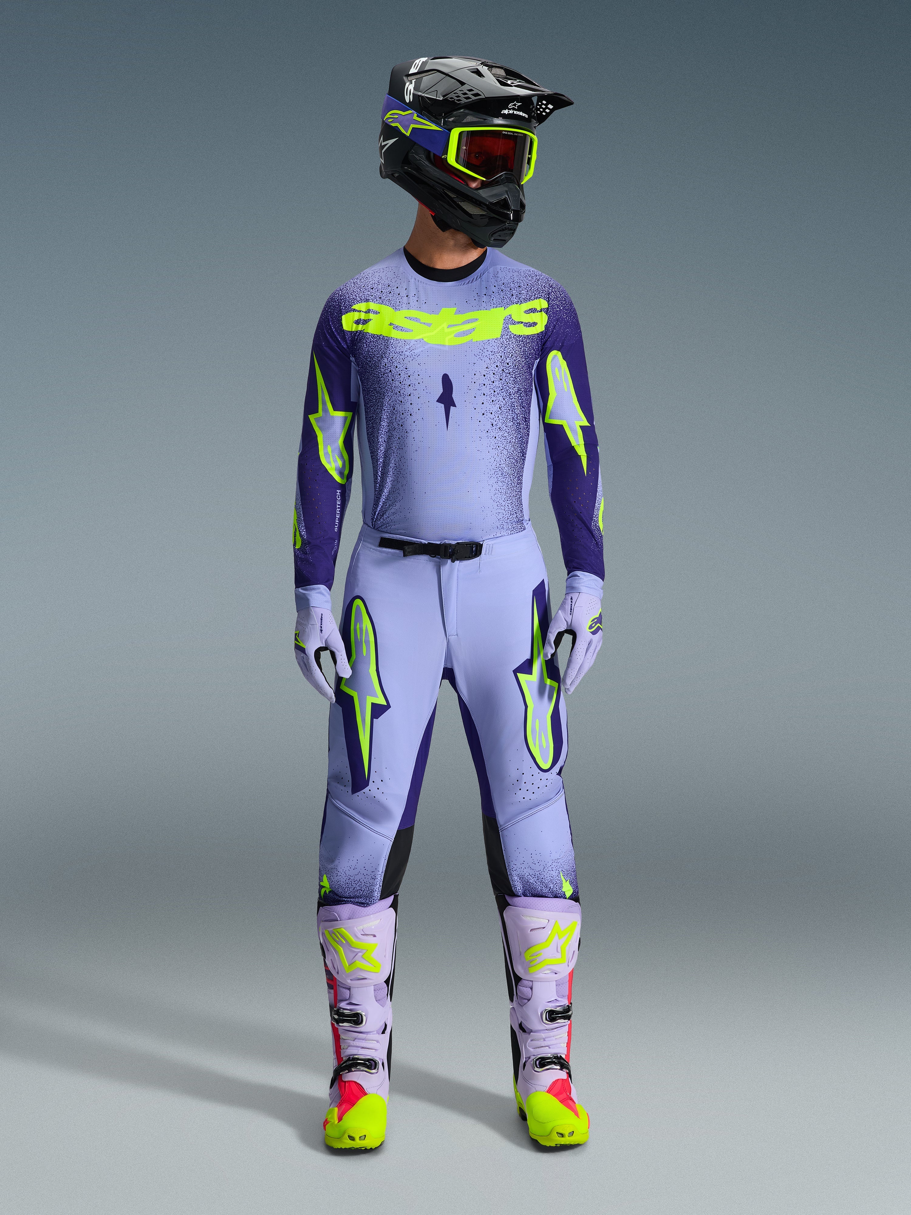 Alpinestars 2026 Supertech Scenz Pants, Motocross Pants, Purple Yellow Fluo, worn as a complete racing gear set with matching lavender jersey, gloves, and boots, featuring bold yellow fluo logos, athletic fit design for professional off-road racing.