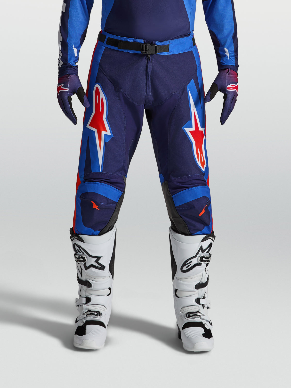 Alpinestars Racer Hunt, calças de motocross para homem, azuis e vermelhas, construção durável pré-curvada com grafismos de estrelas.