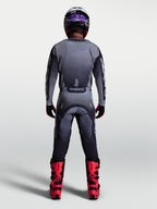 Alpinestars Racer Amber, calças de motocross para homem, cinzento e lilás-claro, vista traseira com botas vermelhas.