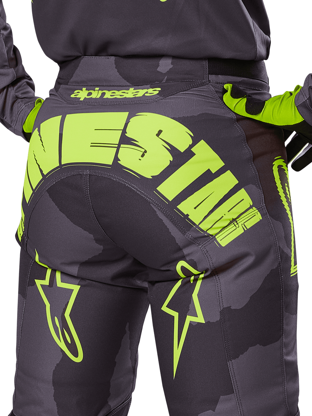Alpinestars 2025 Racer Hollow Pants, calças de motocross, camuflagem escura e amarelo néon, com um grande logótipo Alpinestars amarelo na parte traseira, padrão de camuflagem tática com detalhes amarelos vibrantes e construção durável para corridas todo-o-terreno.