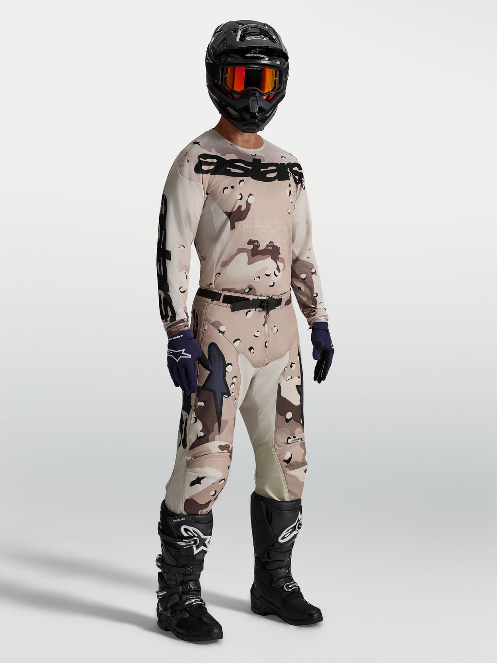 Alpinestars Racer Lone Gear Set, conjunto de camisola e calças de motocross em camuflado bege e castanho com botas pretas.