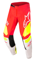 Alpinestars Techstar Factory Pants, calças de motocross, vermelhas com detalhes em amarelo néon e branco, com painéis pretos no interior dos joelhos, grandes logótipos Alpinestars, perfurações para ventilação e fivela de cintura preta ajustável.