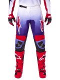 Alpinestars 2025 Fluid Wurx Pants, calças de motocross, roxas e vermelho vivo, usadas com botas e luvas vermelhas a condizer, com logótipos brancos nas coxas e reforços pretos nos joelhos, equipamento de performance para condução todo-o-terreno