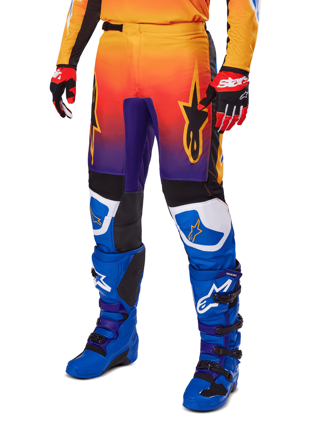 Calças Alpinestars 2025 Fluid Wurx, calças de motocross, gradiente multicolor de laranja, vermelho e roxo com painéis pretos e azuis, usadas com botas azuis e luvas vermelhas, com gráficos do logótipo de estrela e detalhes brancos nos joelhos, equipamento de performance durável para corridas todo-o-terreno