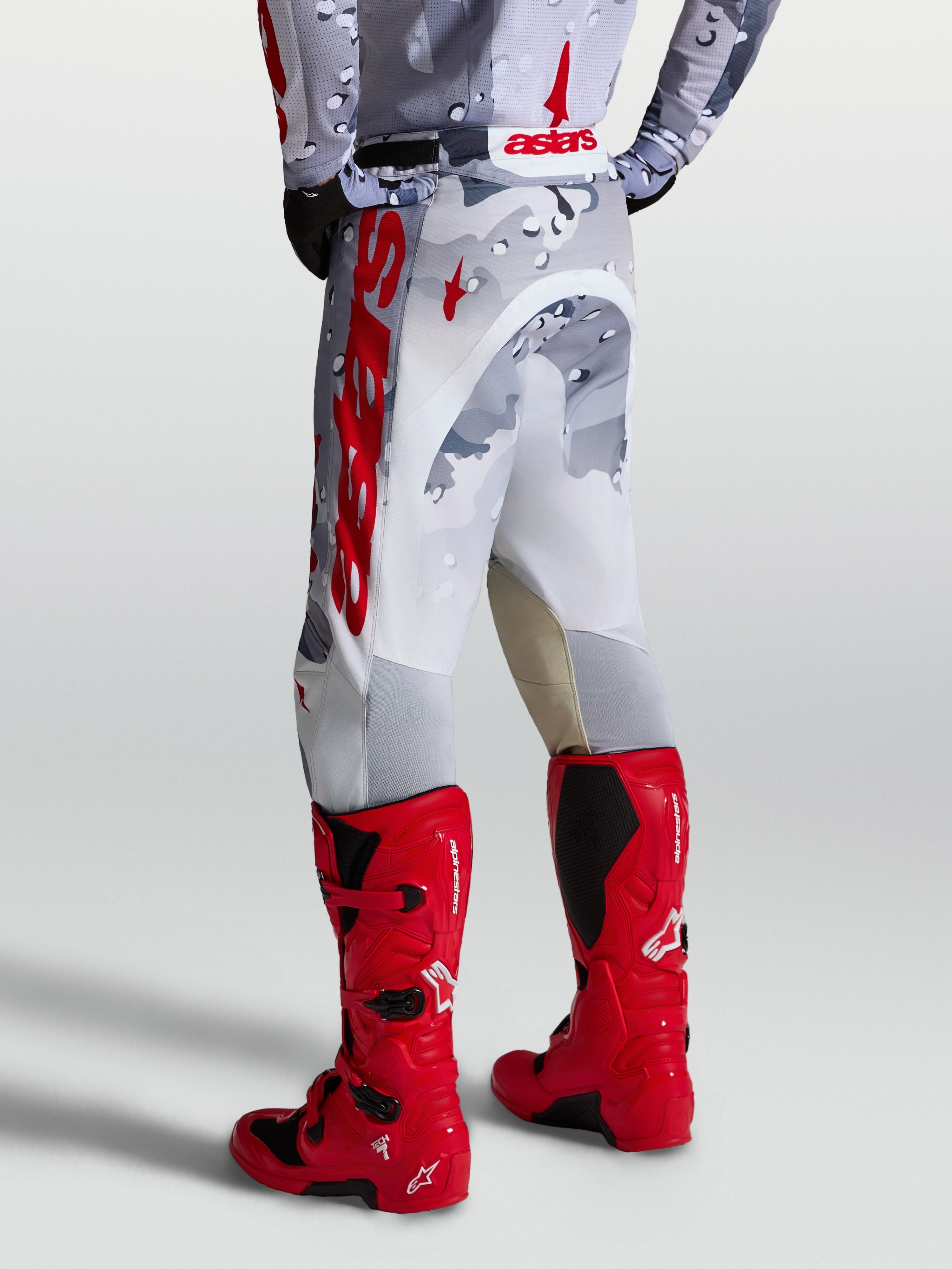 Alpinestars Calças Racer Air Lone, calças de motocross em cinzento camuflado e branco com detalhes vermelhos, vista traseira.