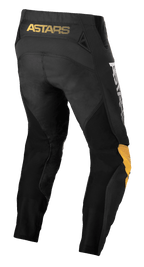 Alpinestars Techstar Quadro Pants, calças de motocross, pretas, amarelas e tangerina, vista traseira com o logótipo 'ASTARS' amarelo na cintura, inserções de malha preta para ventilação e painéis ergonómicos nos joelhos para maior durabilidade em corridas todo-o-terreno