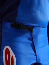 Alpinestars 2026 Fluid Grid Pants, calças de motocross, azuis e vermelhas, vista em grande plano do sistema de fecho de catraca preto na cintura, politecido azul durável com detalhe do logótipo em vermelho e branco, concebidas para desempenho off-road