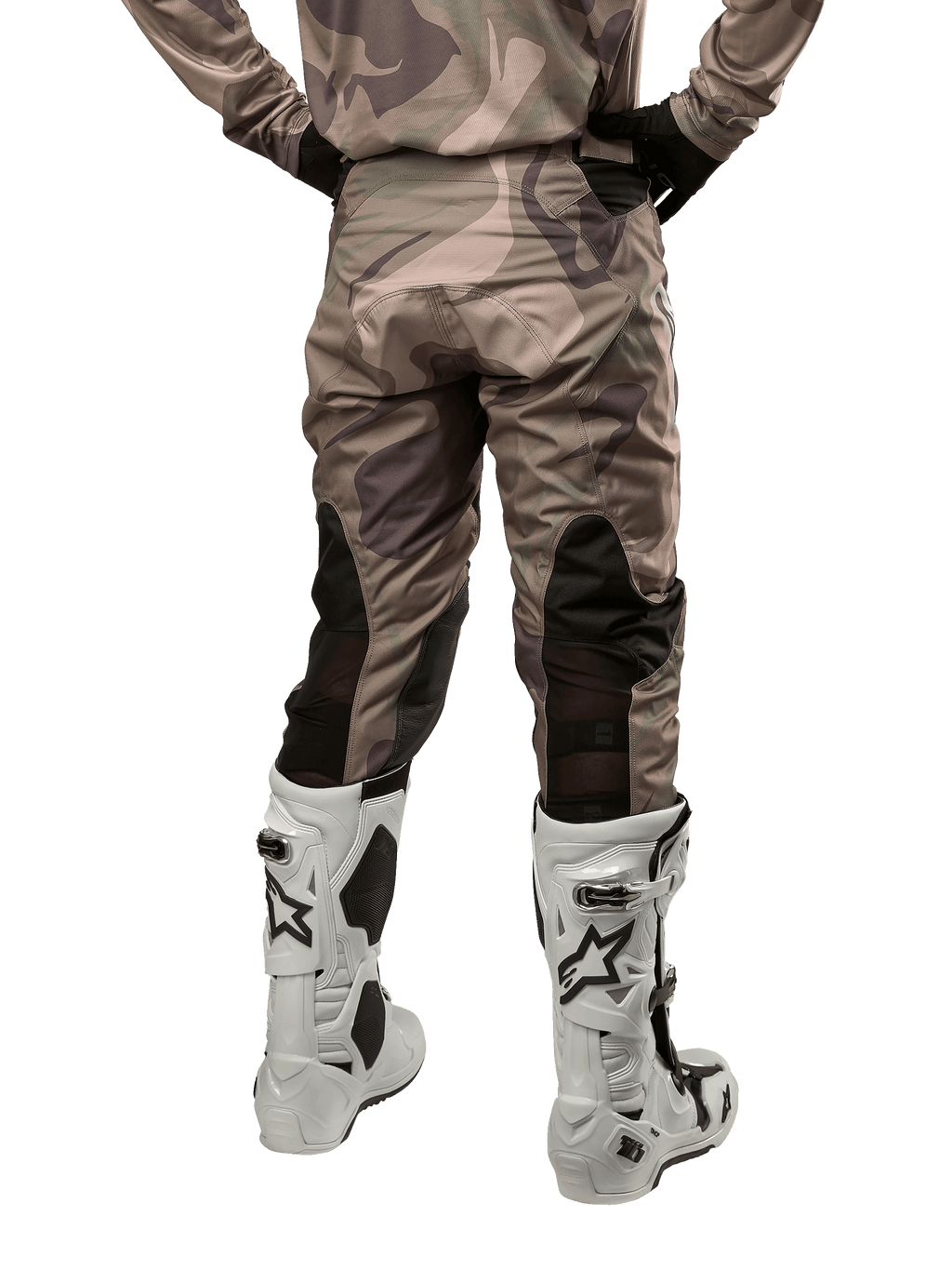 Alpinestars 2024 Racer Tactical Pants, calças de motocross, camuflagem verde militar e castanho, vista traseira mostrando o padrão de camuflagem e painéis elásticos pretos respiráveis na parte inferior das pernas, usadas com botas de motocross brancas, equipamento técnico durável para condução fora de estrada