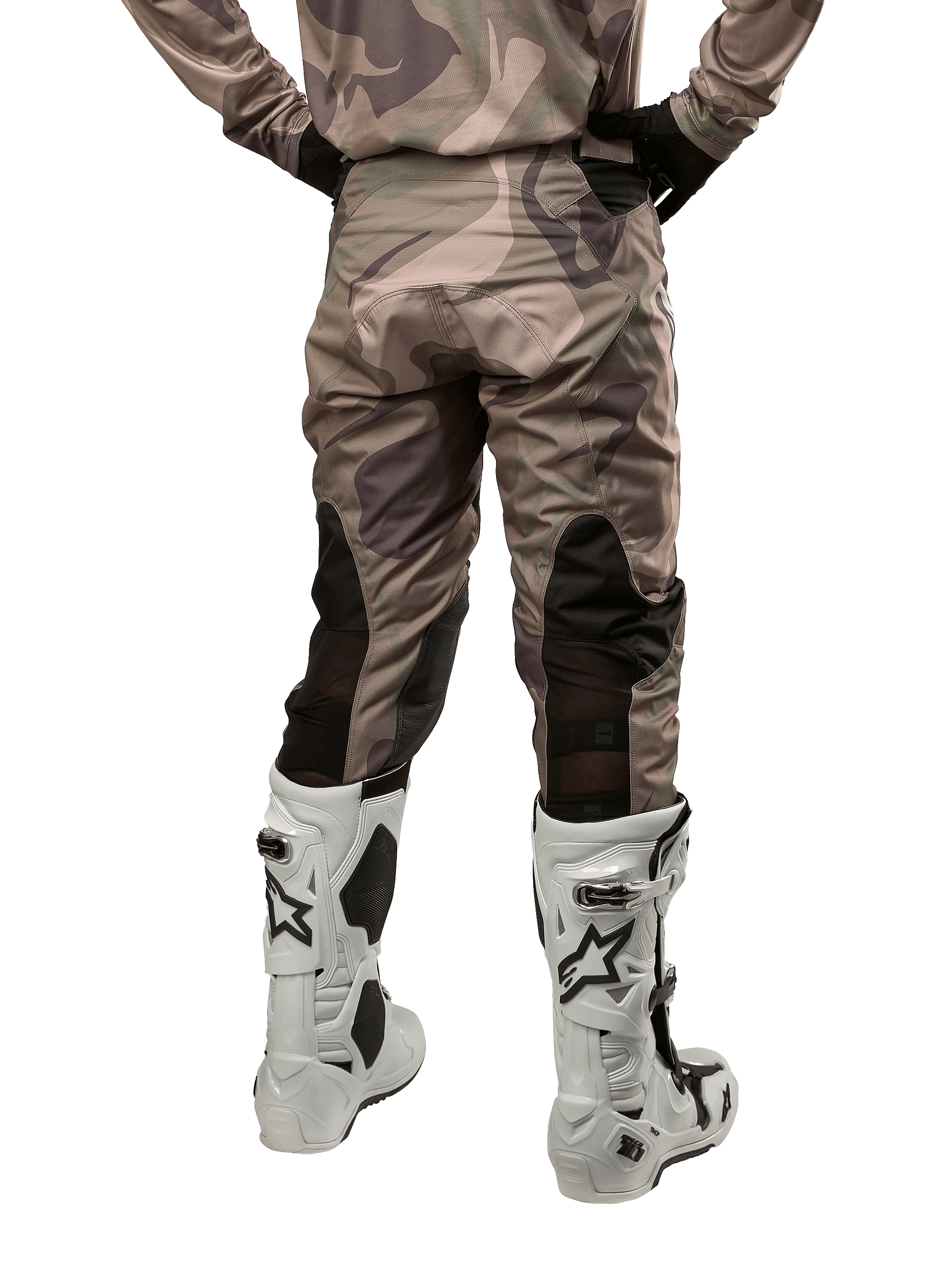 Alpinestars 2024 Racer Tactical Pants, calças de motocross, camuflagem verde militar e castanho, vista traseira mostrando o padrão de camuflagem e painéis elásticos pretos respiráveis na parte inferior das pernas, usadas com botas de motocross brancas, equipamento técnico durável para condução fora de estrada