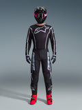 Alpinestars 2026 Fluid Apex Gear Set, fato de motocross, preto com detalhes cinzentos, camisola com grande logótipo Astars branco, calças coordenadas com logótipo em destaque, capacete preto com óculos rosa e botas vermelhas vibrantes, kit de corrida todo-o-terreno completo