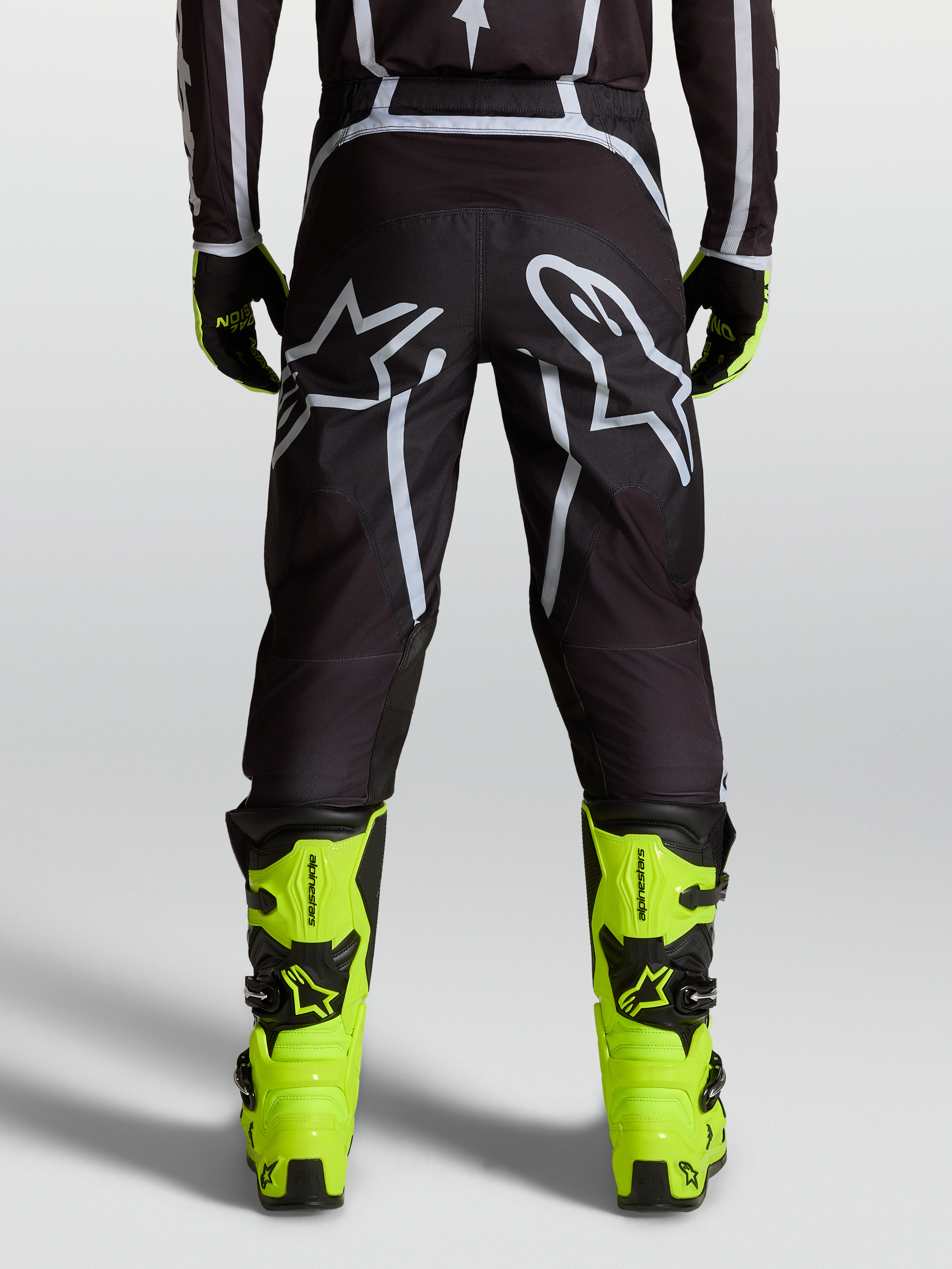 Alpinestars Calças Fluid Apex V2, calças de motocross para homem, pretas e prateadas, vista traseira com logótipo Astars, ajuste ergonómico off-road