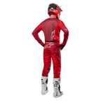 Calças Alpinestars 2024 Racer Hoen e camisola a condizer em Mars Red Burgundy, vista traseira de um piloto de motocross com equipamento completo, incluindo capacete vermelho e botas brancas, destacando o ajuste atlético e a marca para corridas todo-o-terreno.