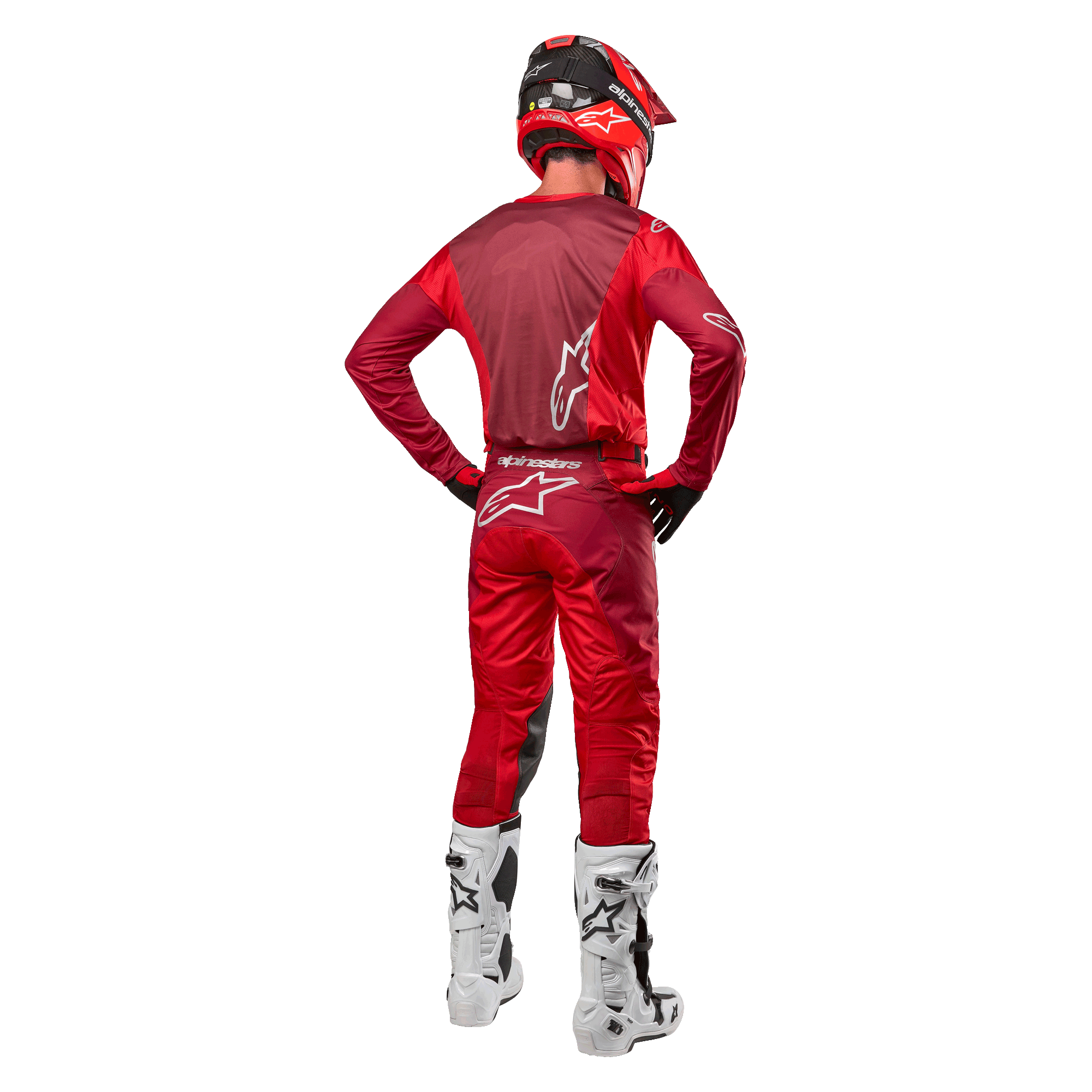 Calças Alpinestars 2024 Racer Hoen e camisola a condizer em Mars Red Burgundy, vista traseira de um piloto de motocross com equipamento completo, incluindo capacete vermelho e botas brancas, destacando o ajuste atlético e a marca para corridas todo-o-terreno.