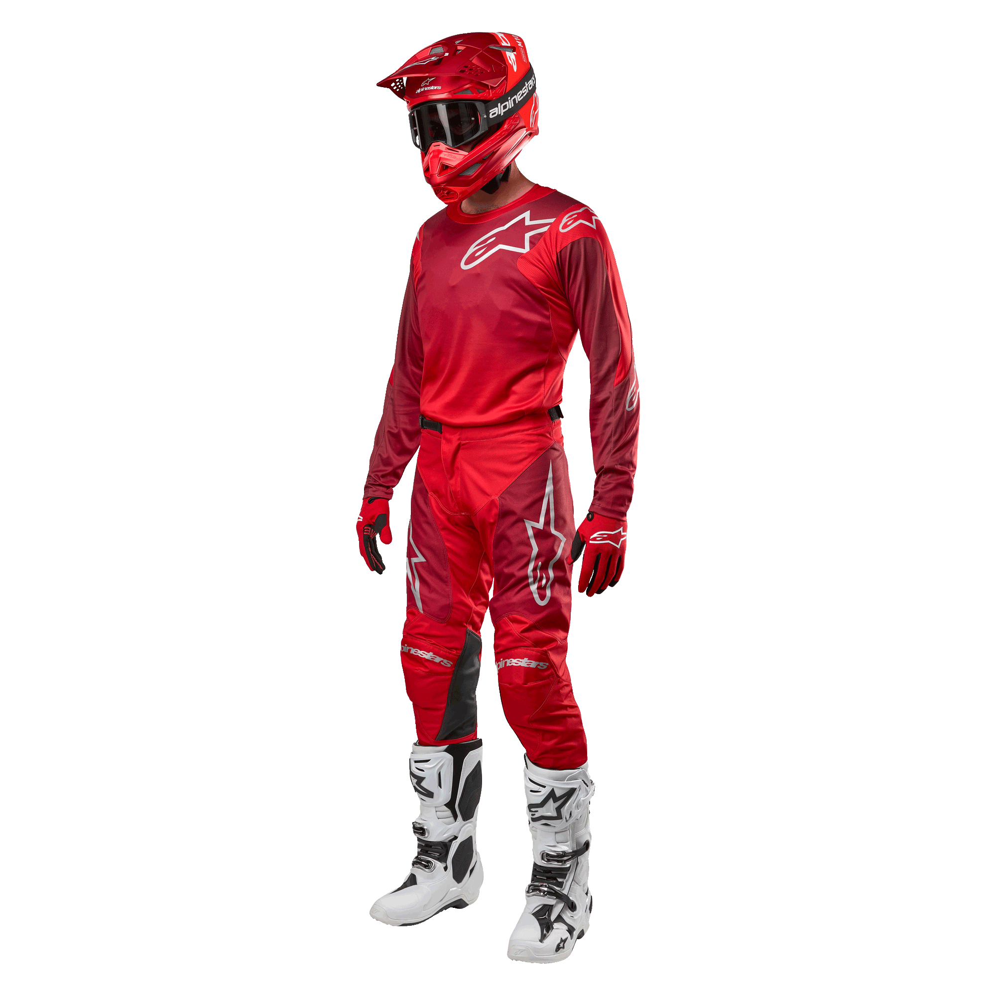 Piloto de motocross a usar equipamento completo de competição, calças e camisola Alpinestars 2024 Racer Hoen em Mars Red Burgundy, capacete vermelho, luvas vermelhas, e botas brancas e pretas, conjunto coordenado para corridas de todo-o-terreno
