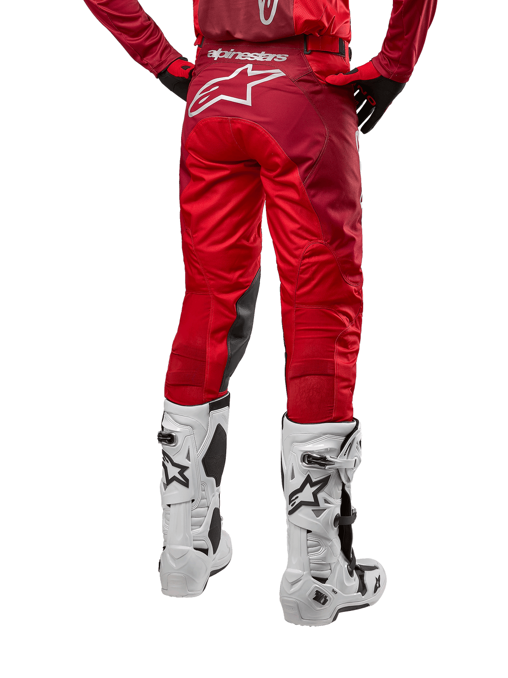 Alpinestars 2024 Racer Hoen Pants, calças de motocross, Vermelho Mars Burgundy, vista traseira com um grande logótipo Astar branco na parte posterior, painéis internos pretos nos joelhos, usadas com botas de motocross brancas, equipamento de alto desempenho para todo-o-terreno