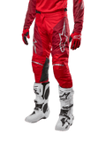 Calças Alpinestars Racer Hoen 2024, calças de motocross, Vermelho Mars e Borgonha, usadas com camisola e luvas vermelhas a condizer e botas brancas, com painéis de joelho em pele preta e logótipos brancos, equipamento técnico durável para todo-o-terreno