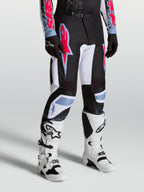 Alpinestars Calças Fluid Drag, calças de motocross para homem, pretas e brancas com pormenores em vermelho fluorescente e azul claro, construção ergonómica pré-curvada para performance todo-o-terreno.