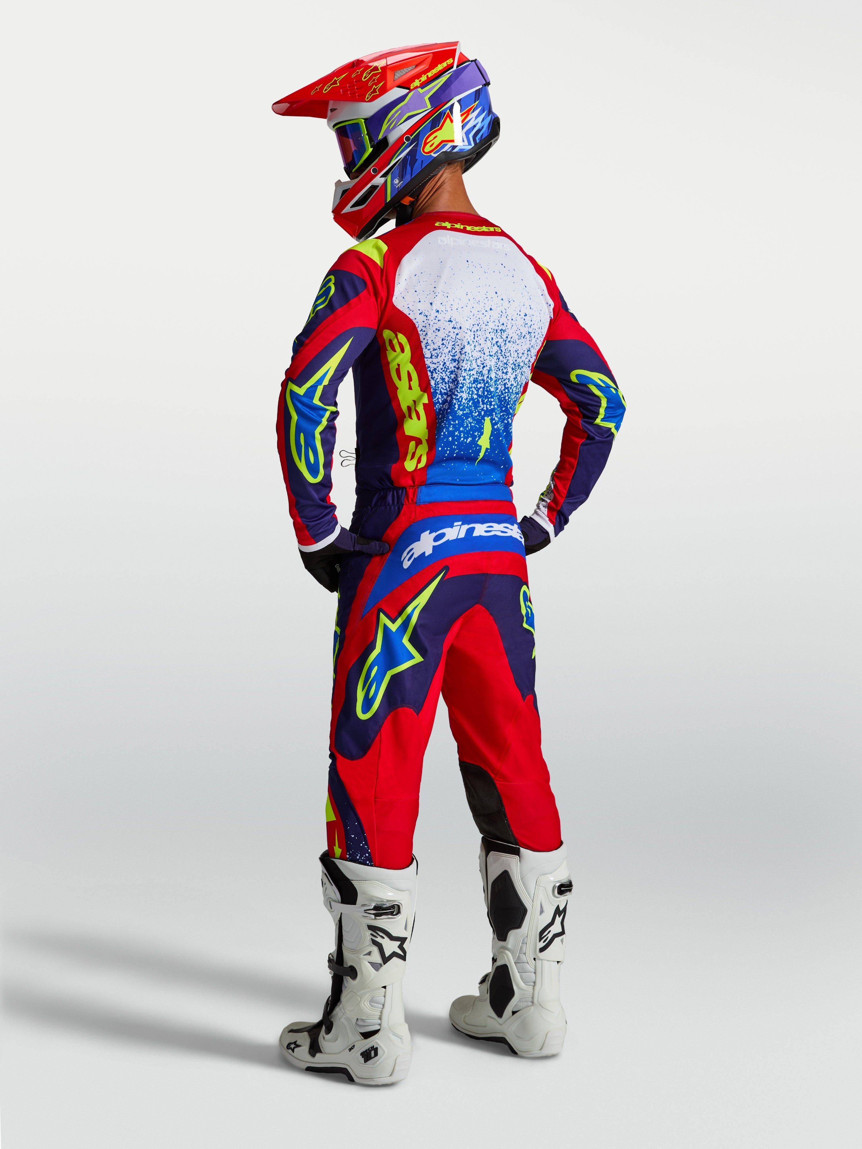 Alpinestars Calças Fluid Drag e Conjunto Fluid Drag, fato de motocross para homem, azul e vermelho, vista traseira em modelo.