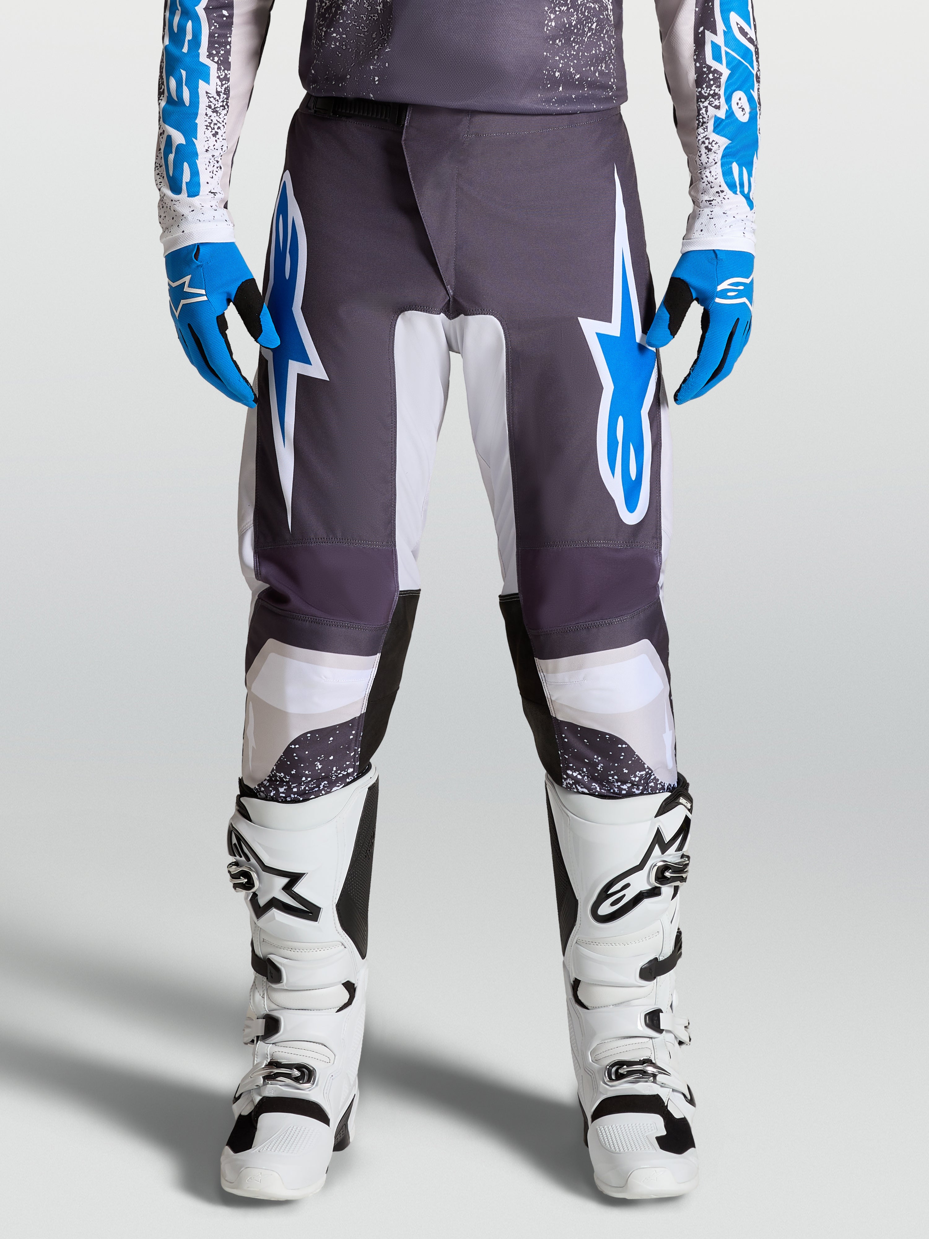 Alpinestars Fluid Drag Pants for motocross, Graystone and Ucla Blue, with pre-curved legs and ergonomic polyfabric protection.
