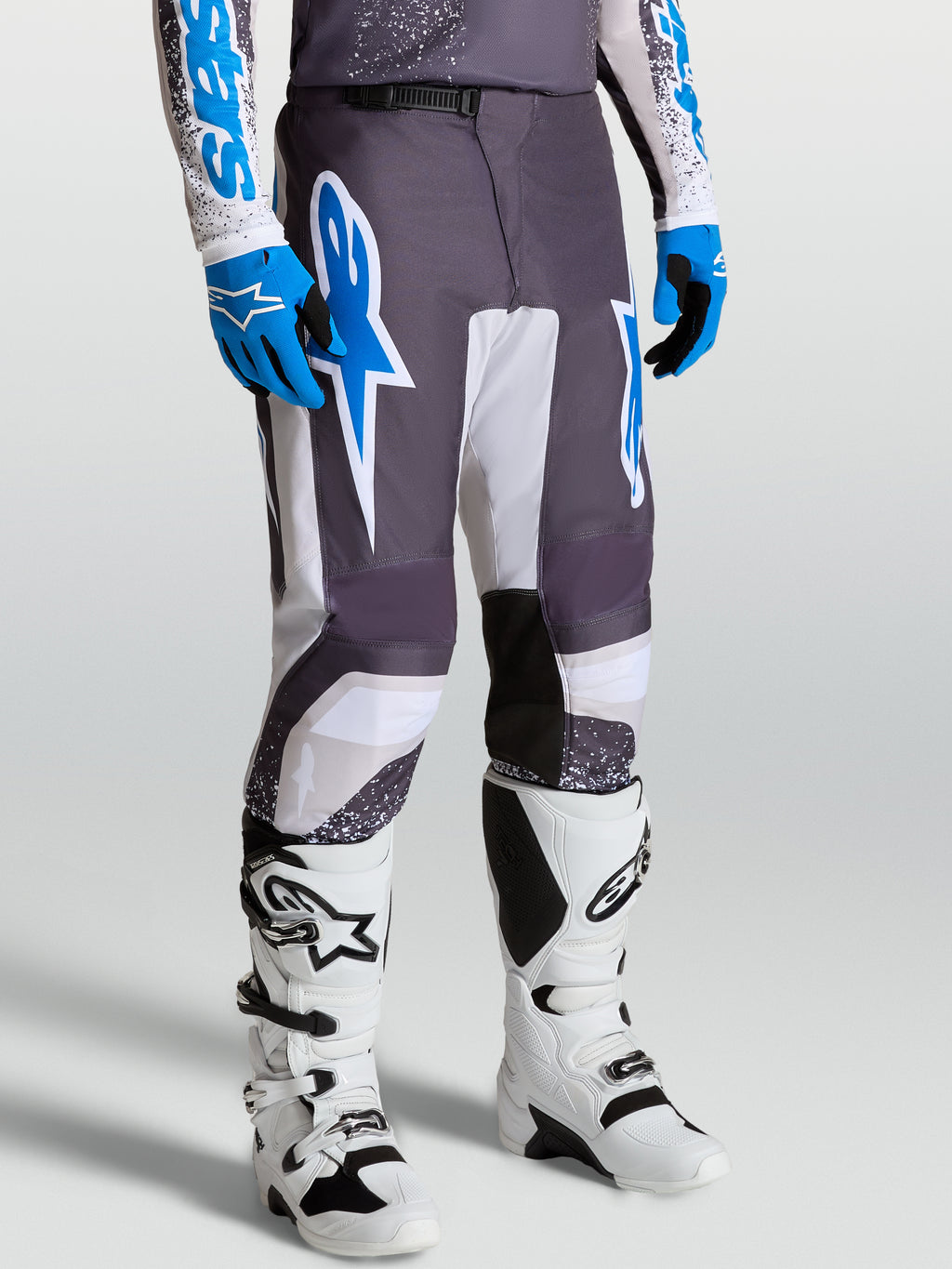 Calças Alpinestars Fluid Drag, calças de motocross para homem, cinzentas, azuis e lilás, com ajuste ergonómico desportivo.