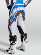Calças Alpinestars Fluid Drag, calças de motocross em cinzento e azul, vista traseira com padrão ergonómico 3D.