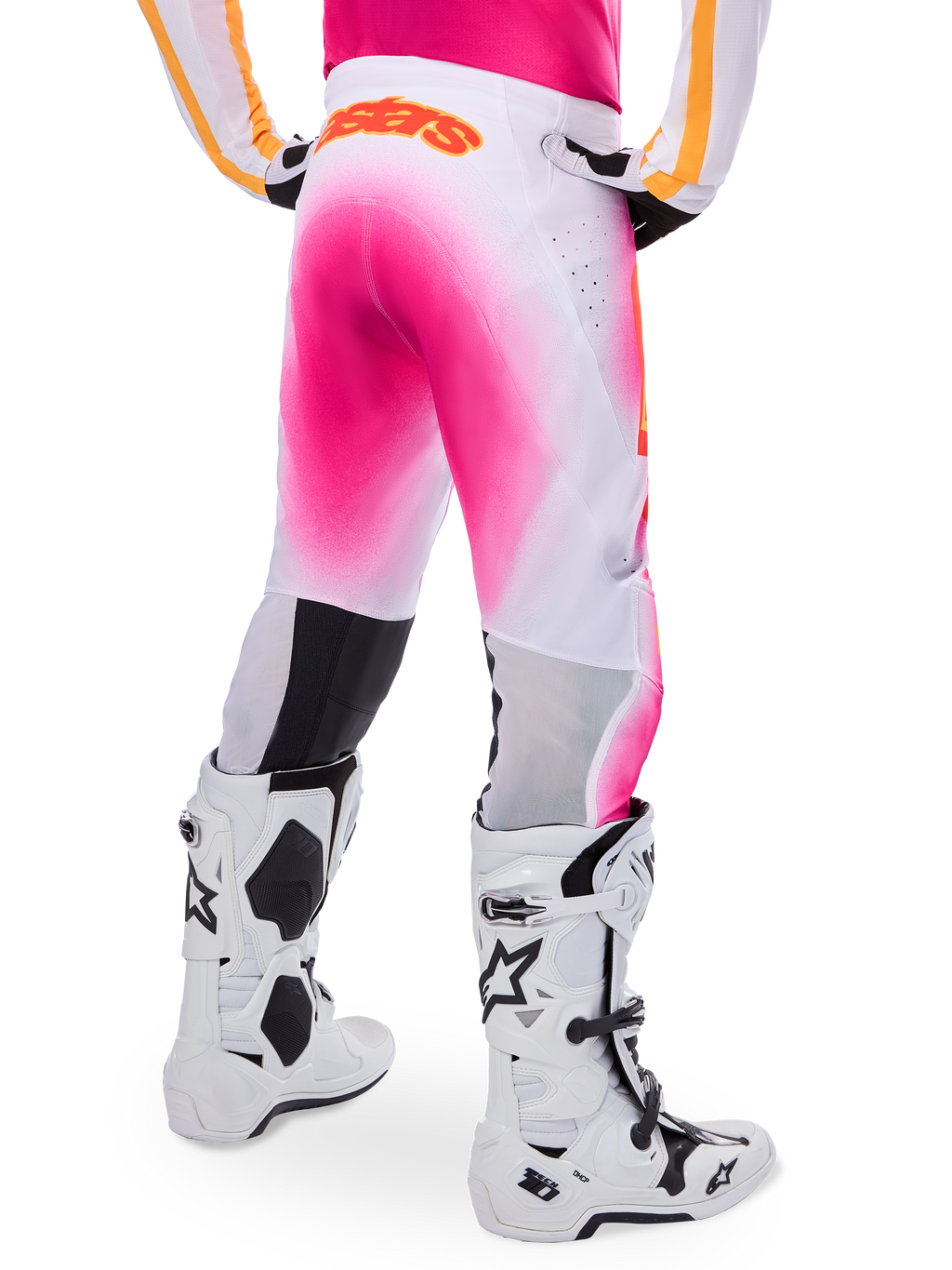 Alpinestars Supertech AFD MIG Limited Edition Motocross Pants, Pink and White, rear view featuring a vibrant pink gradient spray effect, orange logo on the back waist, paired with white and black Tech 10 boots, professional off-road racing apparel