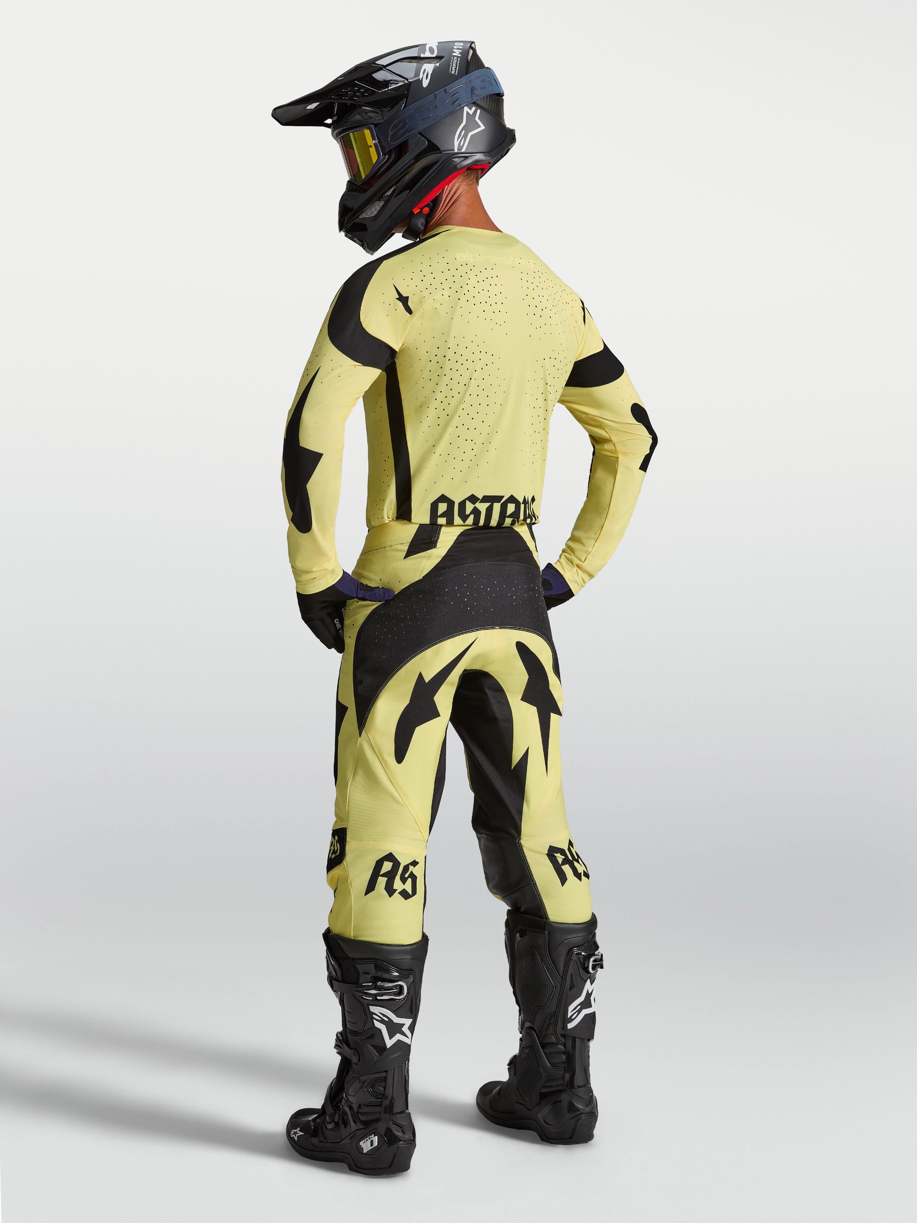 Alpinestars Calças Techstar Atrox e Techstar Atrox Gear Set, equipamento de motocross para alto desempenho, amarelo e preto, vista traseira num modelo com botas de corrida.