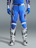 Alpinestars 2026 Racer Air Portl Pants, calças de motocross, Azul Ucla e branco, usadas com luvas azuis a condizer e botas brancas, com fecho de cintura preto, grandes logótipos de estrela brancos nas coxas e tecido perfurado para maior fluxo de ar durante corridas off-road.