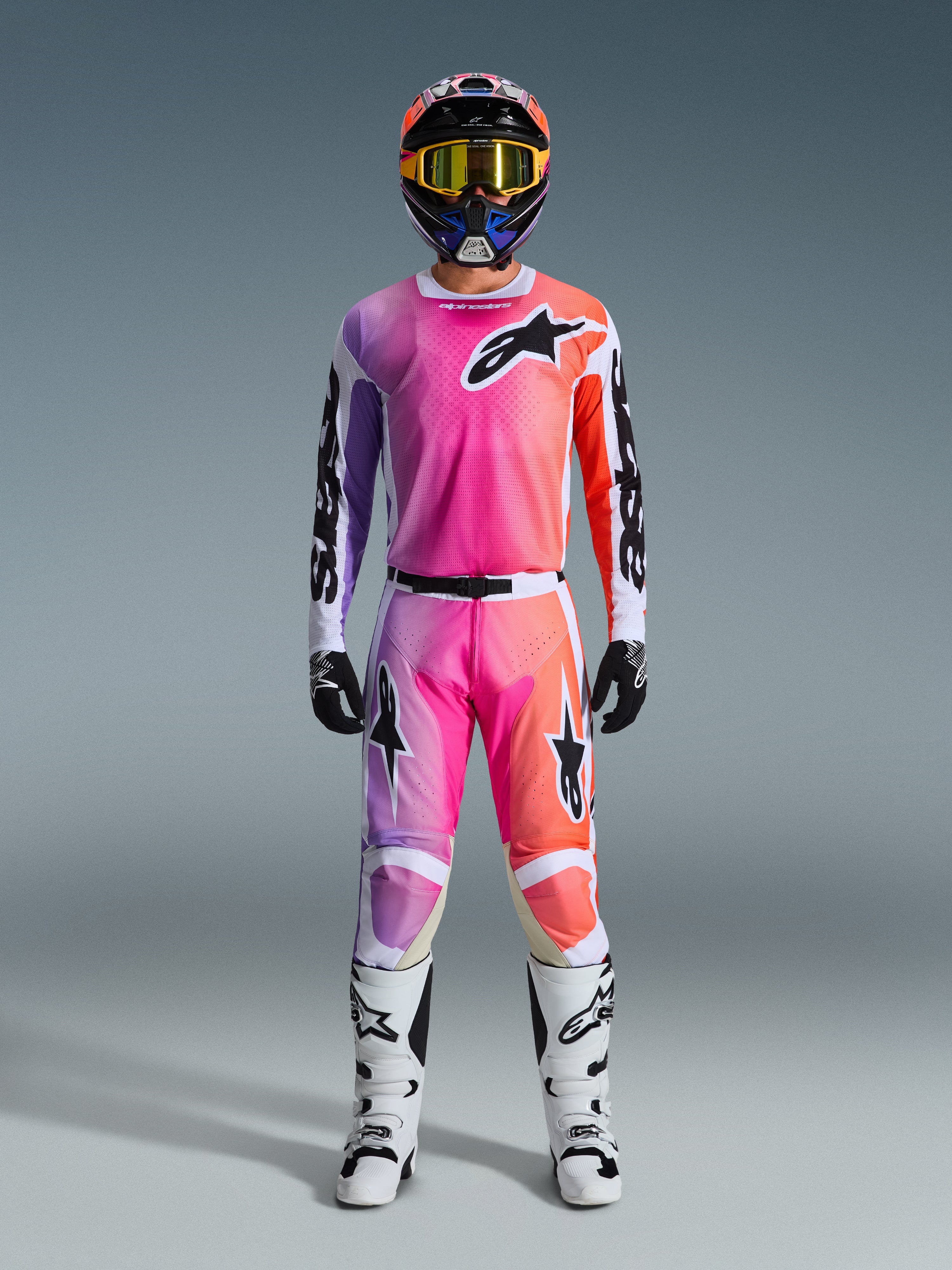 Alpinestars 2026 Racer Air Portl Gear Set, equipamento de motocross, rosa, roxo e laranja, conjunto completo com capacete a condizer, óculos amarelos, luvas pretas e botas brancas, com o logótipo de estrela em destaque no peito e nas pernas.