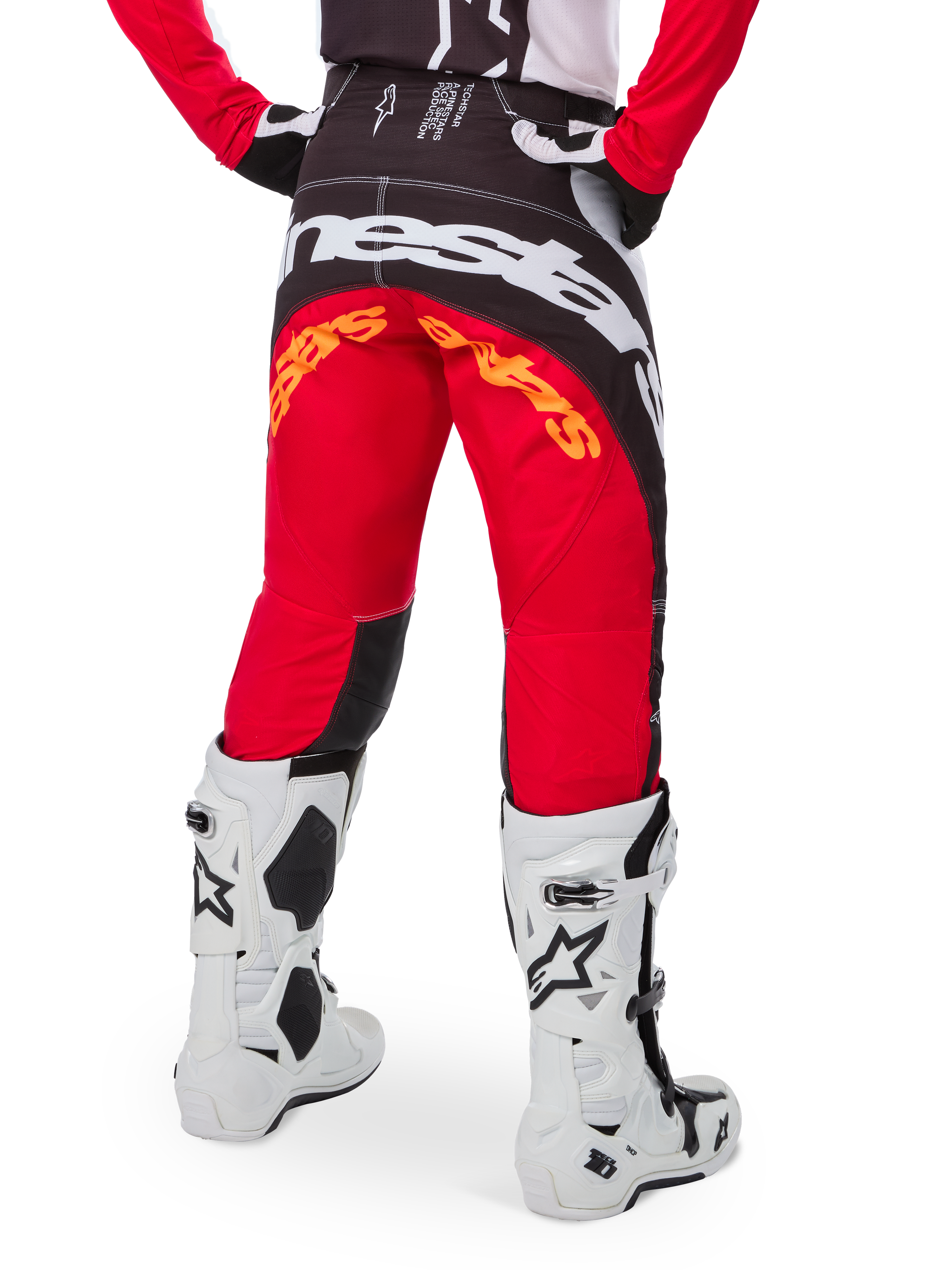 Alpinestars Limited Edition Techstar Deep Pants, Motocross Pants, Black White and High Red, rear view featuring bold white Alpinestars logo across the seat and orange branding, worn with white technical boots for professional off-road racing.