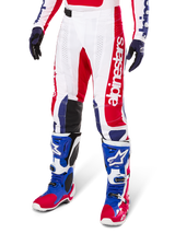 Alpinestars Limited Edition Techstar Fortitude Pants, calças de motocross, em vermelho vibrante, branco e azul, usadas com botas e luvas de todo-o-terreno a condizer, com marca vertical na perna, painéis perfurados respiráveis e secções de joelho reforçadas a preto, design de ajuste atlético de corrida