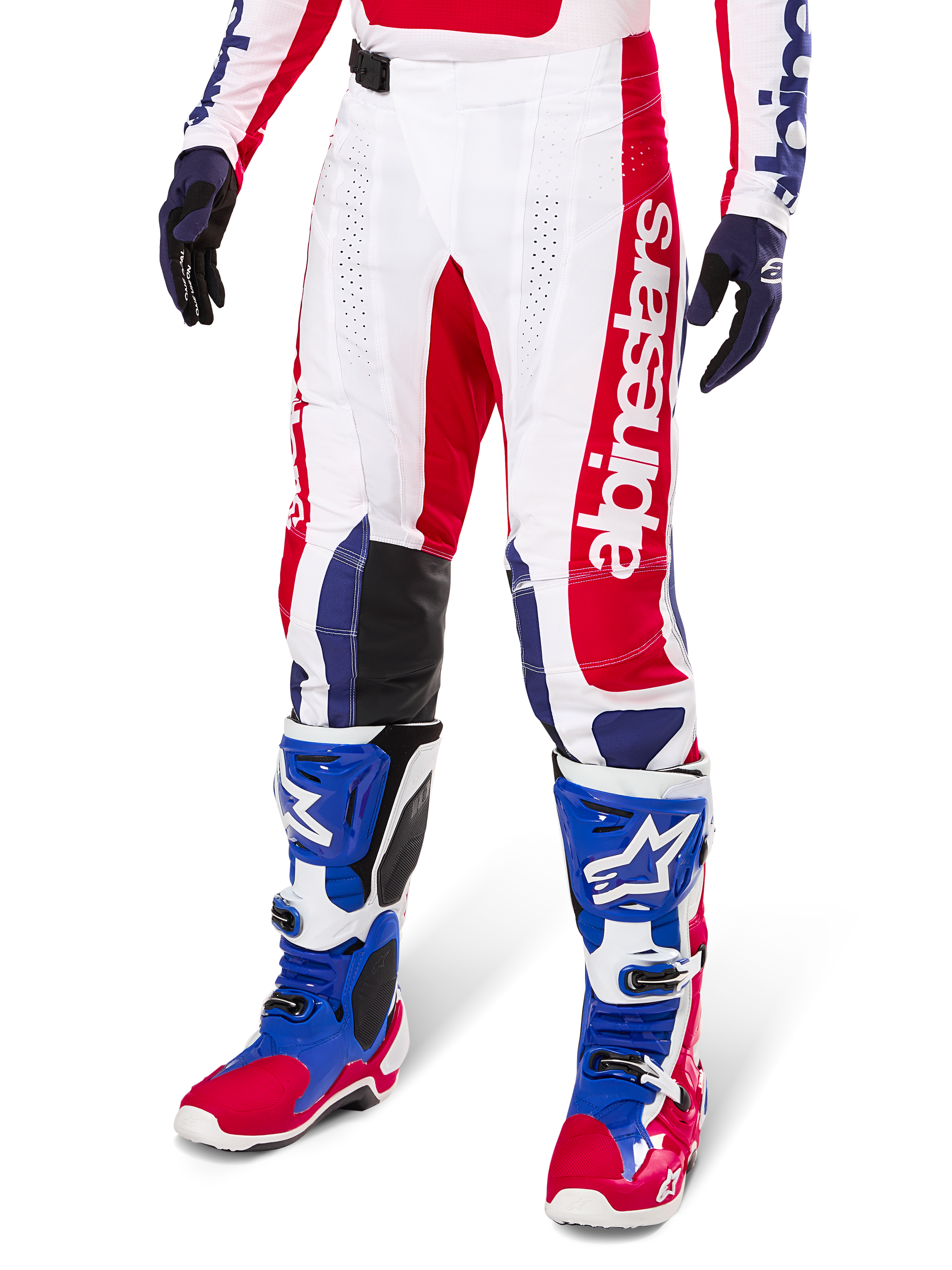 Alpinestars Limited Edition Techstar Fortitude Pants, calças de motocross, em vermelho vibrante, branco e azul, usadas com botas e luvas de todo-o-terreno a condizer, com marca vertical na perna, painéis perfurados respiráveis e secções de joelho reforçadas a preto, design de ajuste atlético de corrida
