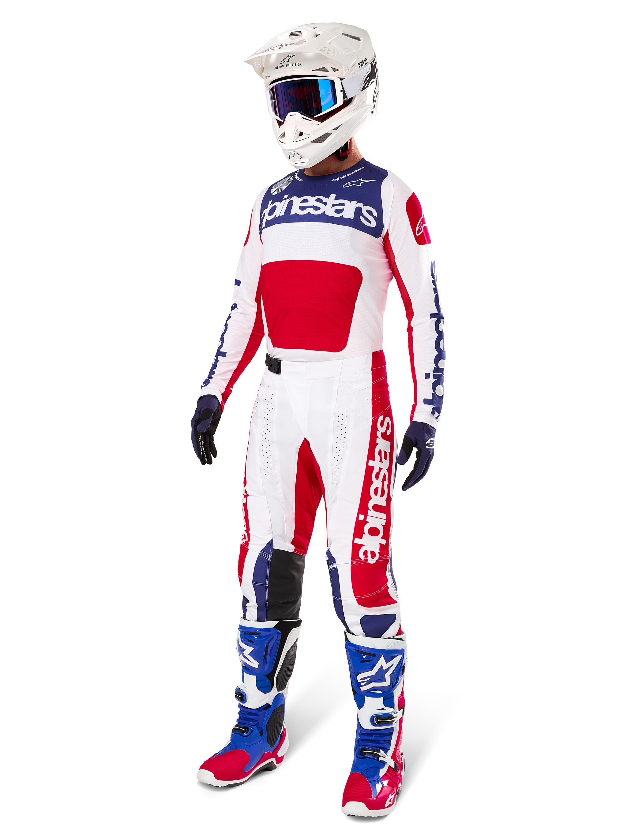 Calças Alpinestars Limited Edition Techstar Fortitude, conjunto de equipamento de motocross, em vermelho, branco e azul, usadas com camisola a condizer, capacete branco, óculos azuis e botas azuis e vermelhas, fato de corrida profissional coordenado para competição de todo-o-terreno
