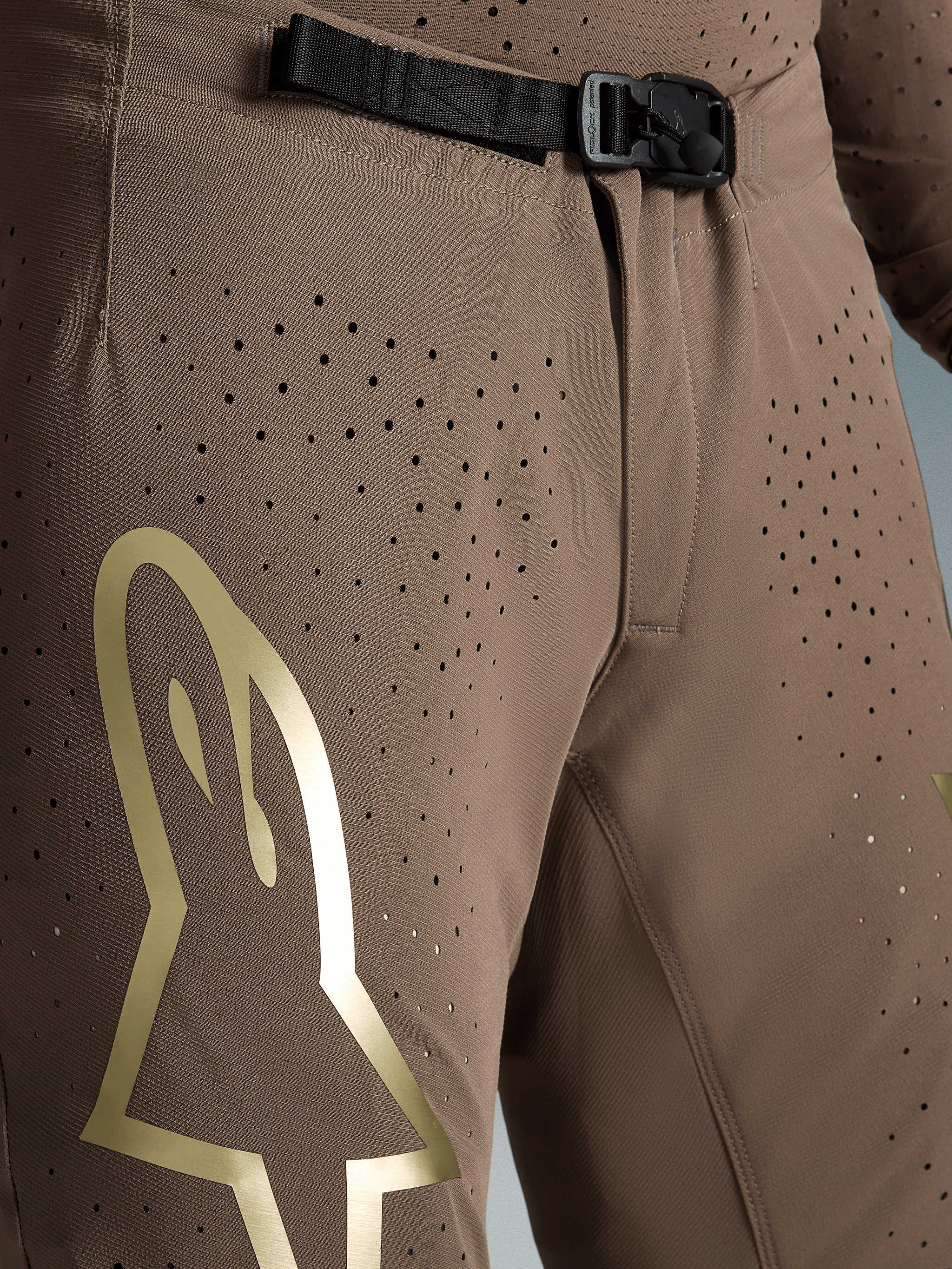 Alpinestars Supertech Air Gold Edição Limitada, calças de motocross castanhas e douradas com fivela SX1 e tecido perfurado.