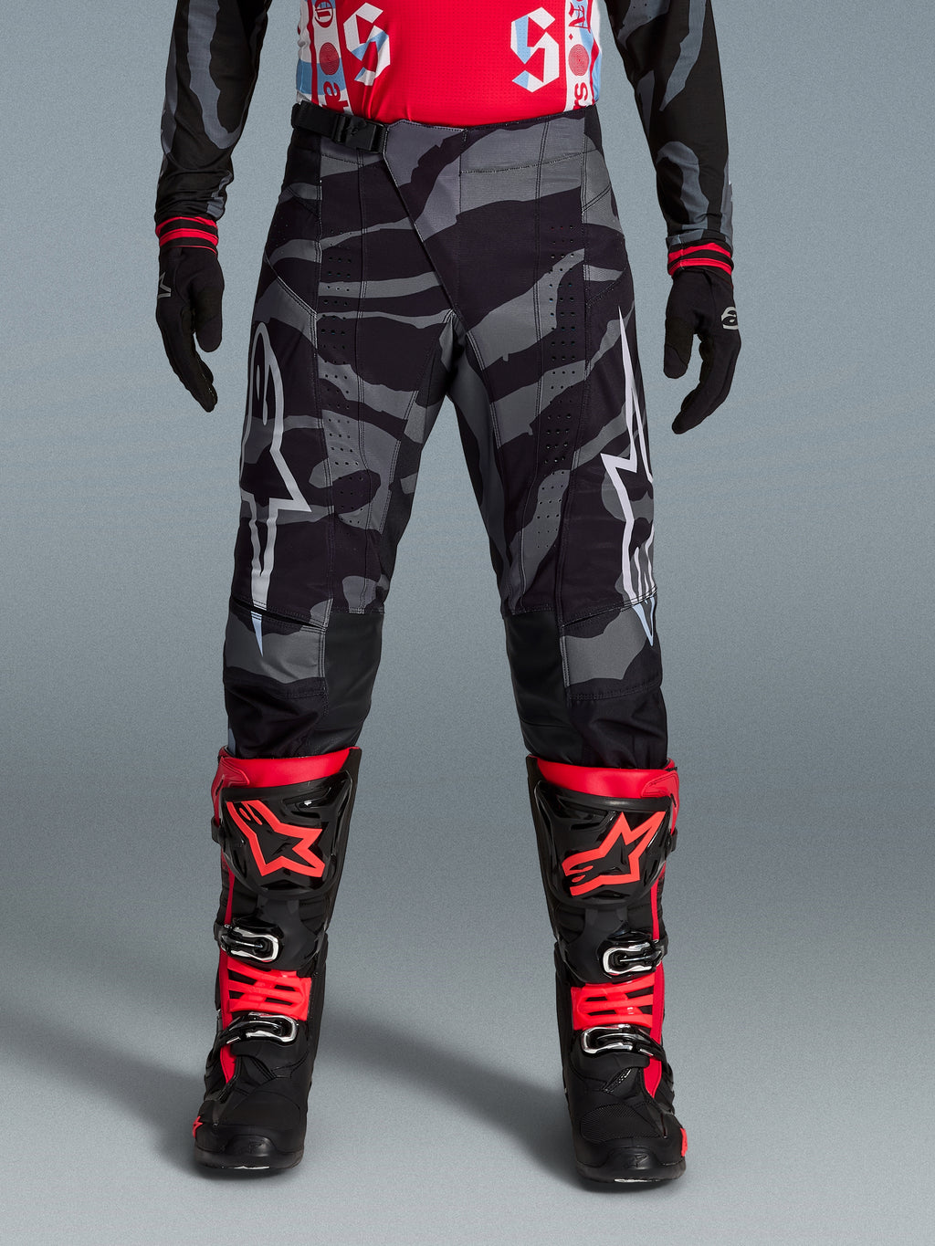 Calças Alpinestars Techstar Beast Coast Edição Limitada, equipamento de motocross com padrão de camuflagem preto e cinzento, pormenores em laranja, design ergonómico para performance off-road