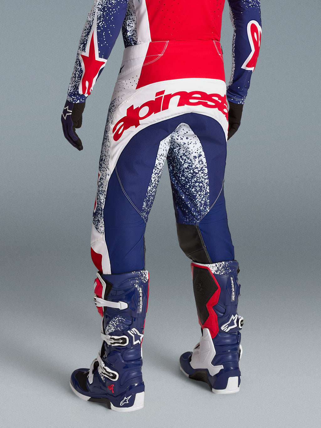 Alpinestars Techstar Unity, calças de motocross vermelhas, brancas e azuis, logótipo traseiro no modelo, edição limitada.